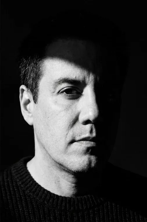Retrato en blanco y negro de Edson Noyola, medio rostro en penumbra